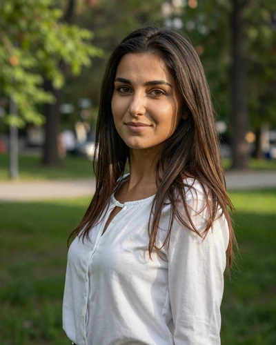 Alina, 27-year-old Moldovan woman from Chișinău with dark brown hair smiling in a sunlit city park