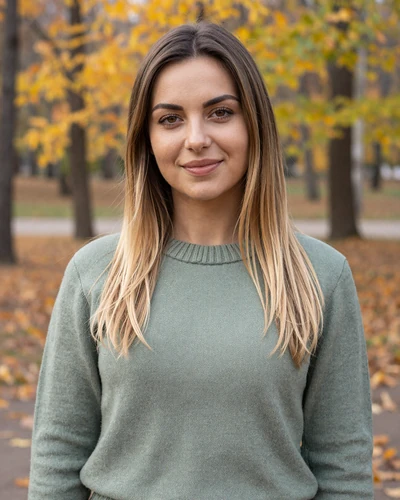 Darya, 26-year-old Belarusian woman from Minsk with dark blonde hair smiling in an autumn park